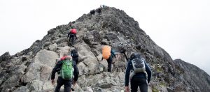 team climbing a rocky hill near denver depicting an example of team development